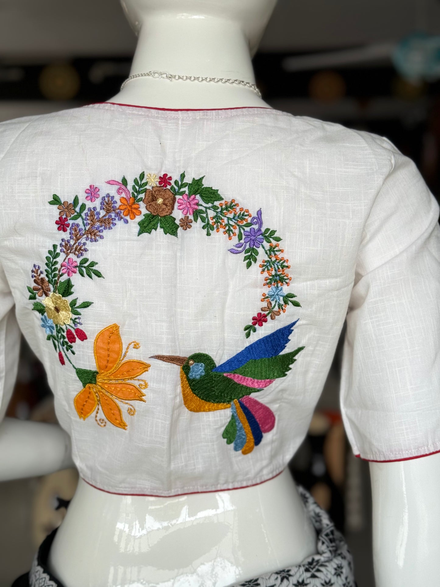 White cotton blouse with colorful bird and flowers embroidery at the back