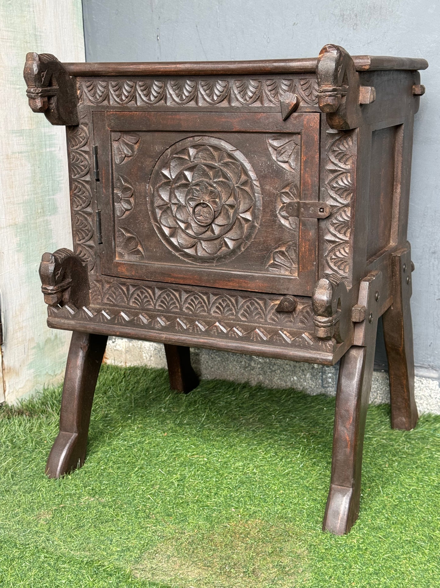 Wooden side table with carved flower door and horses on the corners