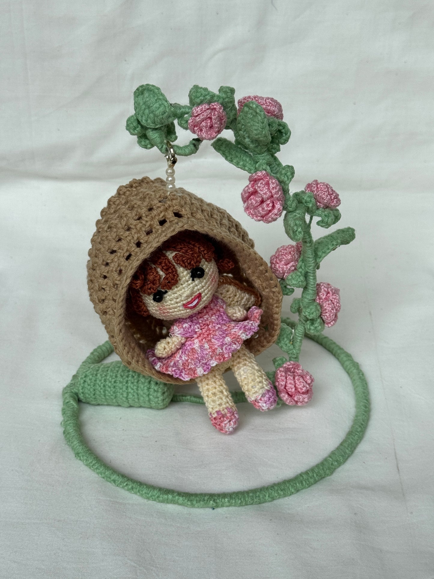 Girl in a swing adorned with flowers - handcrafted crochet decor with LED lights