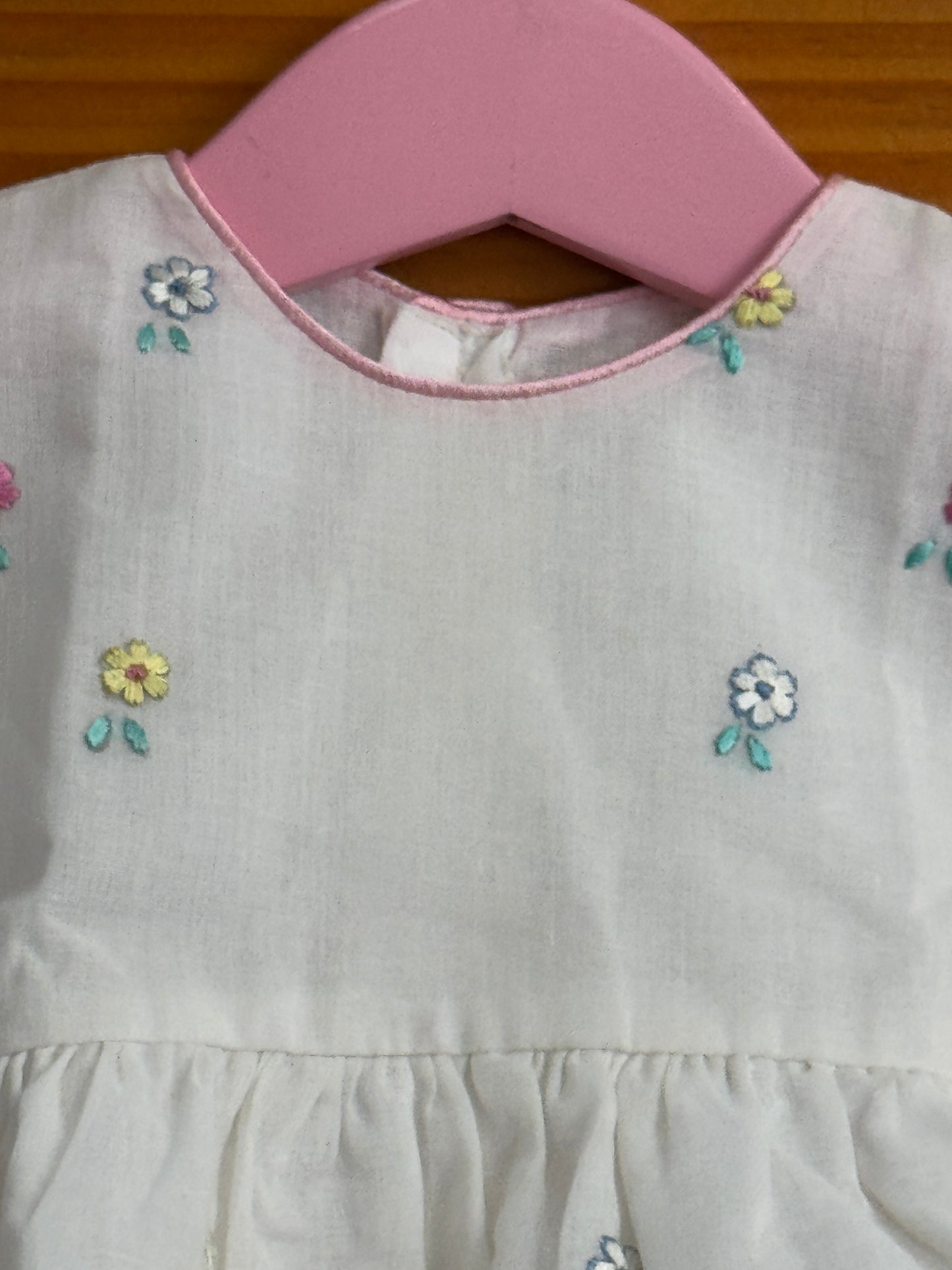 White cotton baby frock with cute embroidery and pink trims