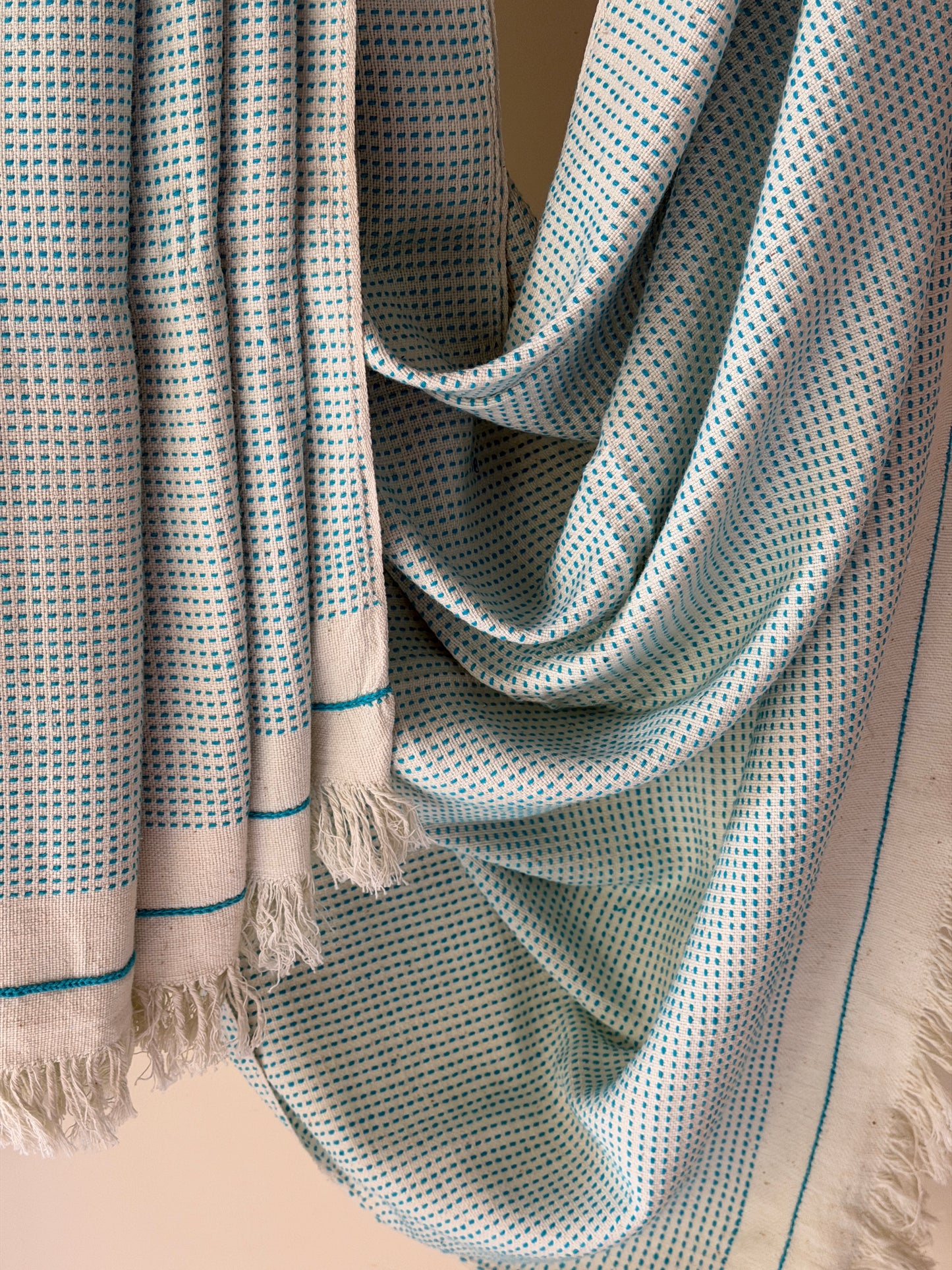 Off-white handwoven cotton sofa throw with blue woven stripes all over