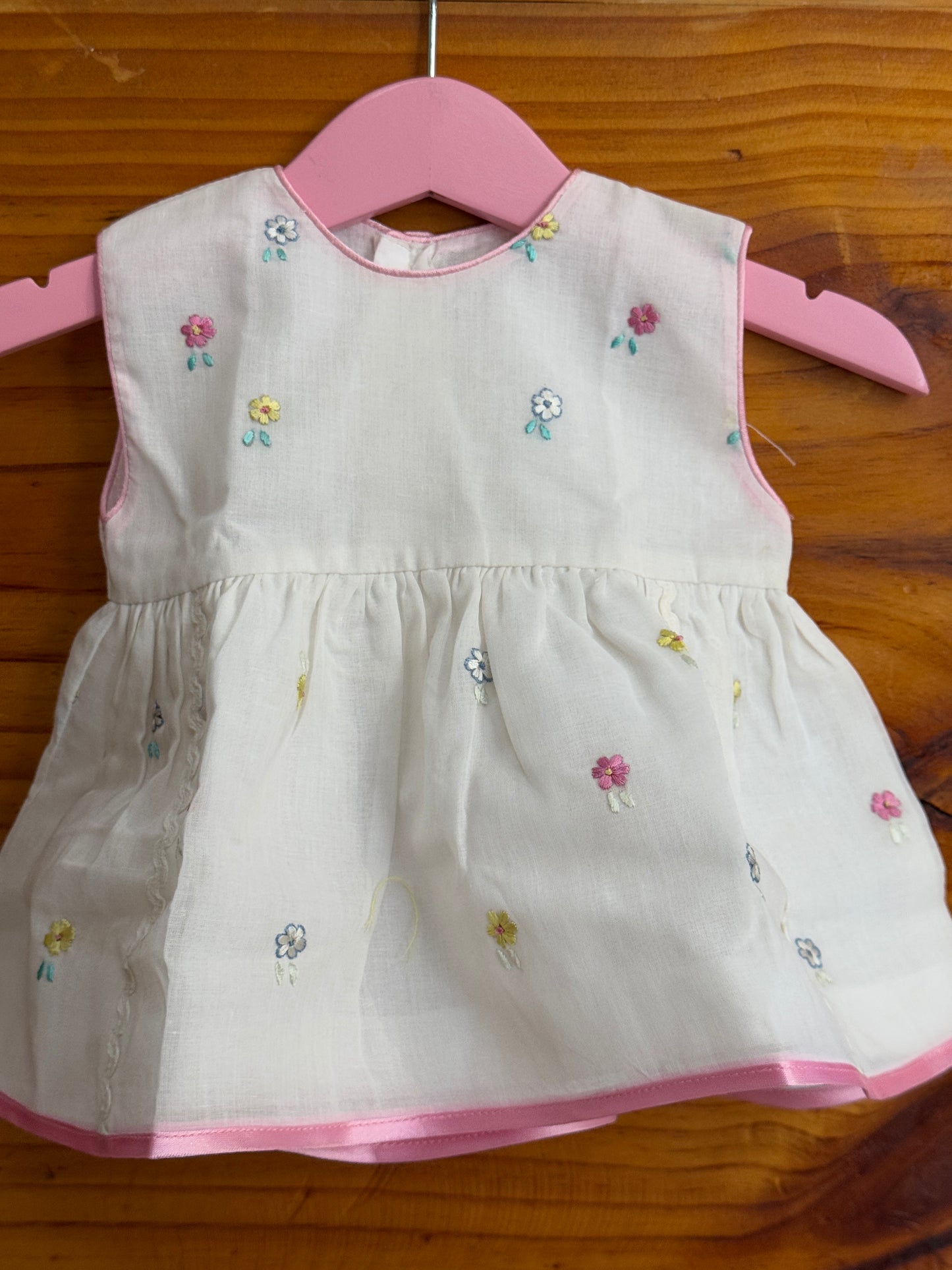 White cotton baby frock with cute embroidery and pink trims