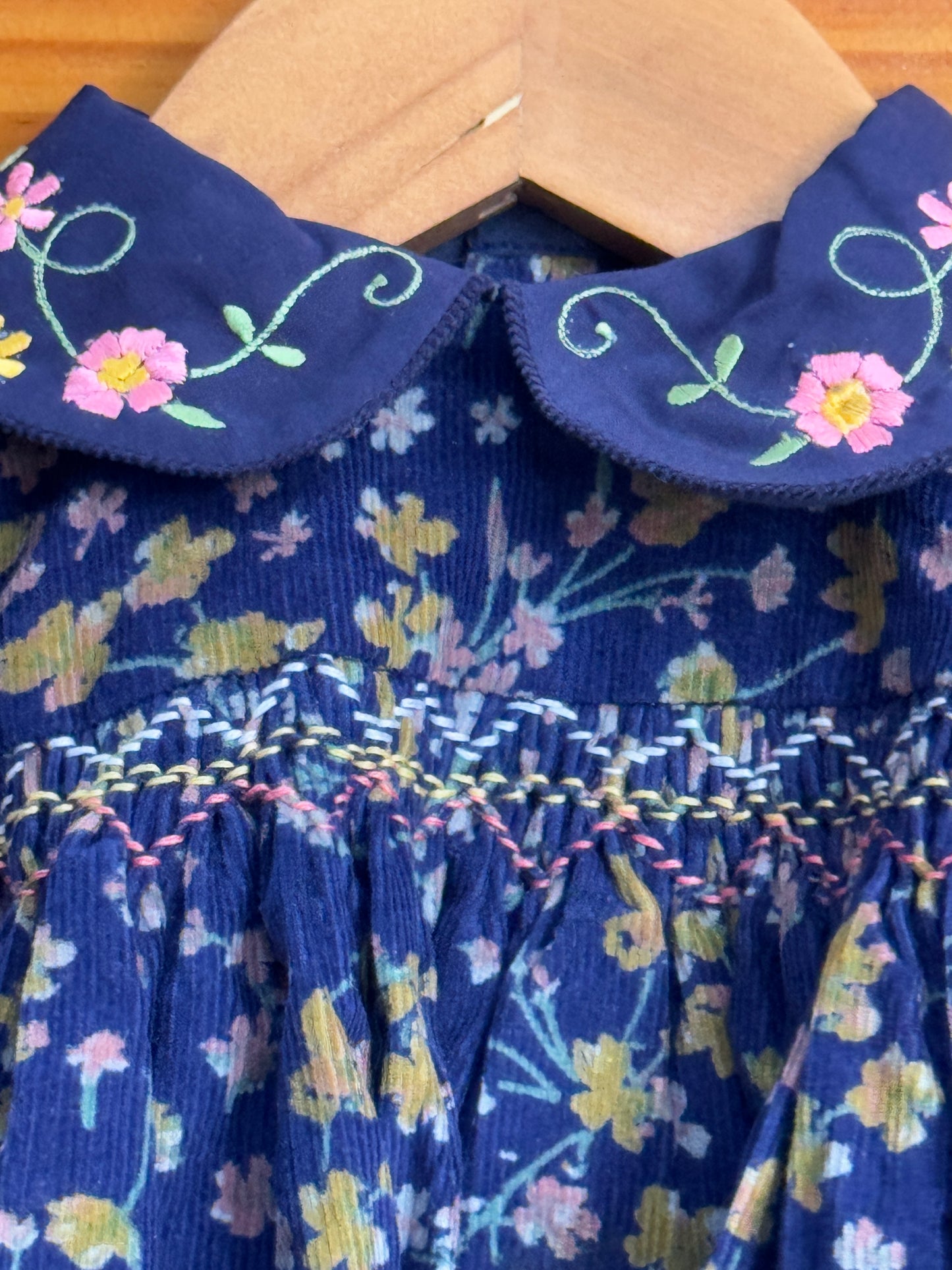 Bright blue floral print Corduroy soft frock with peter pan collar and smocking embroidery