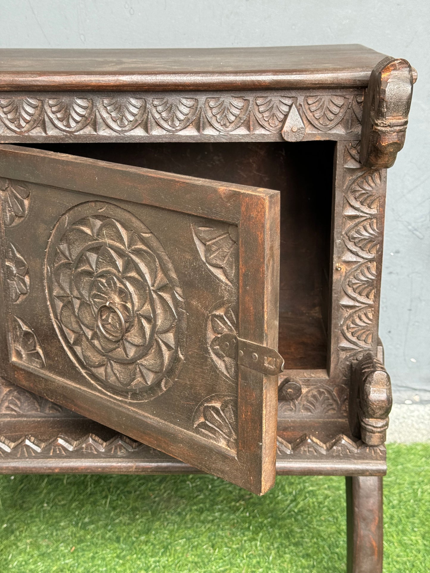 Wooden side table with carved flower door and horses on the corners