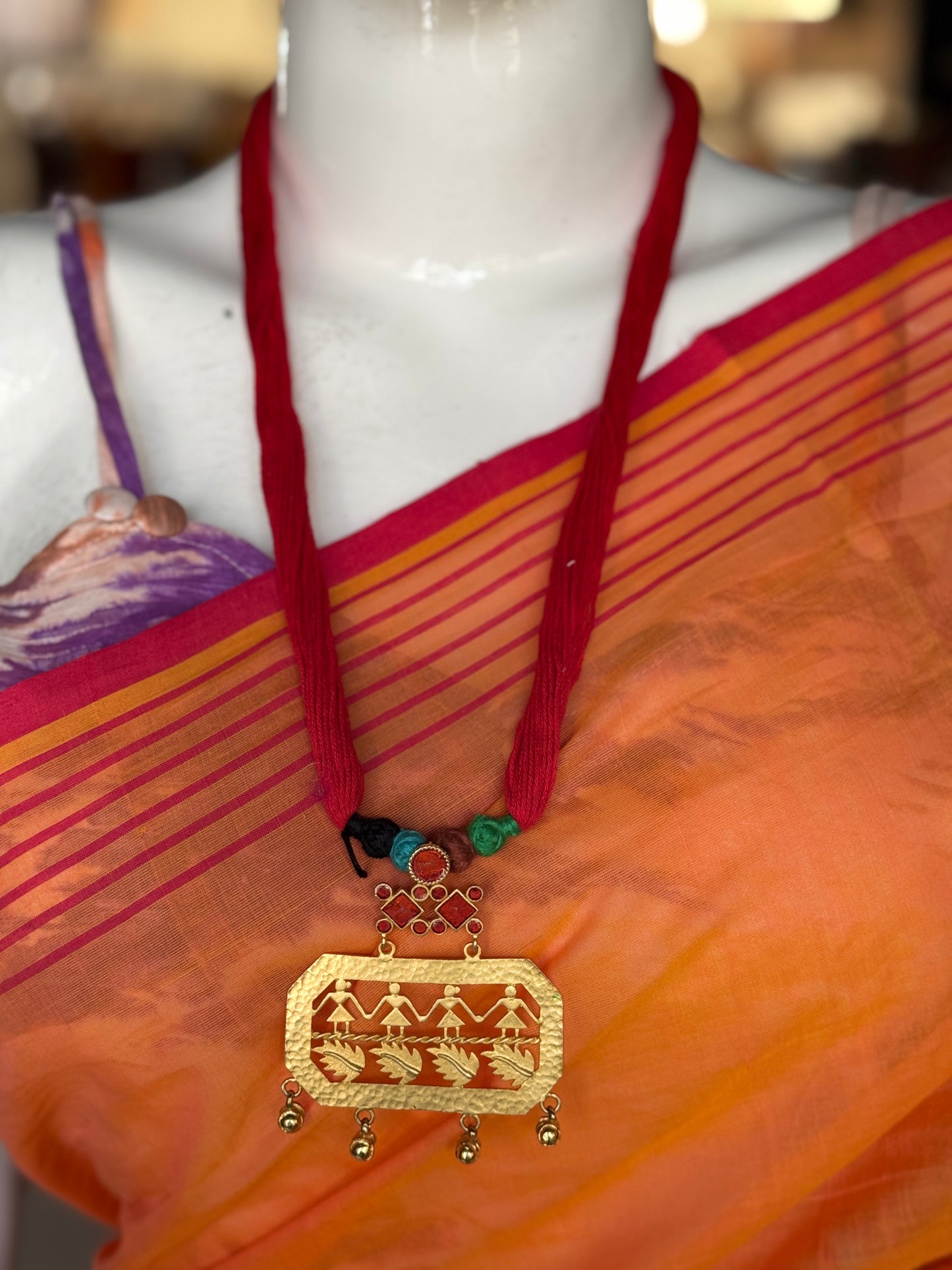 Red thread neckpiece with silver alloy metallic pendant with dancing figures