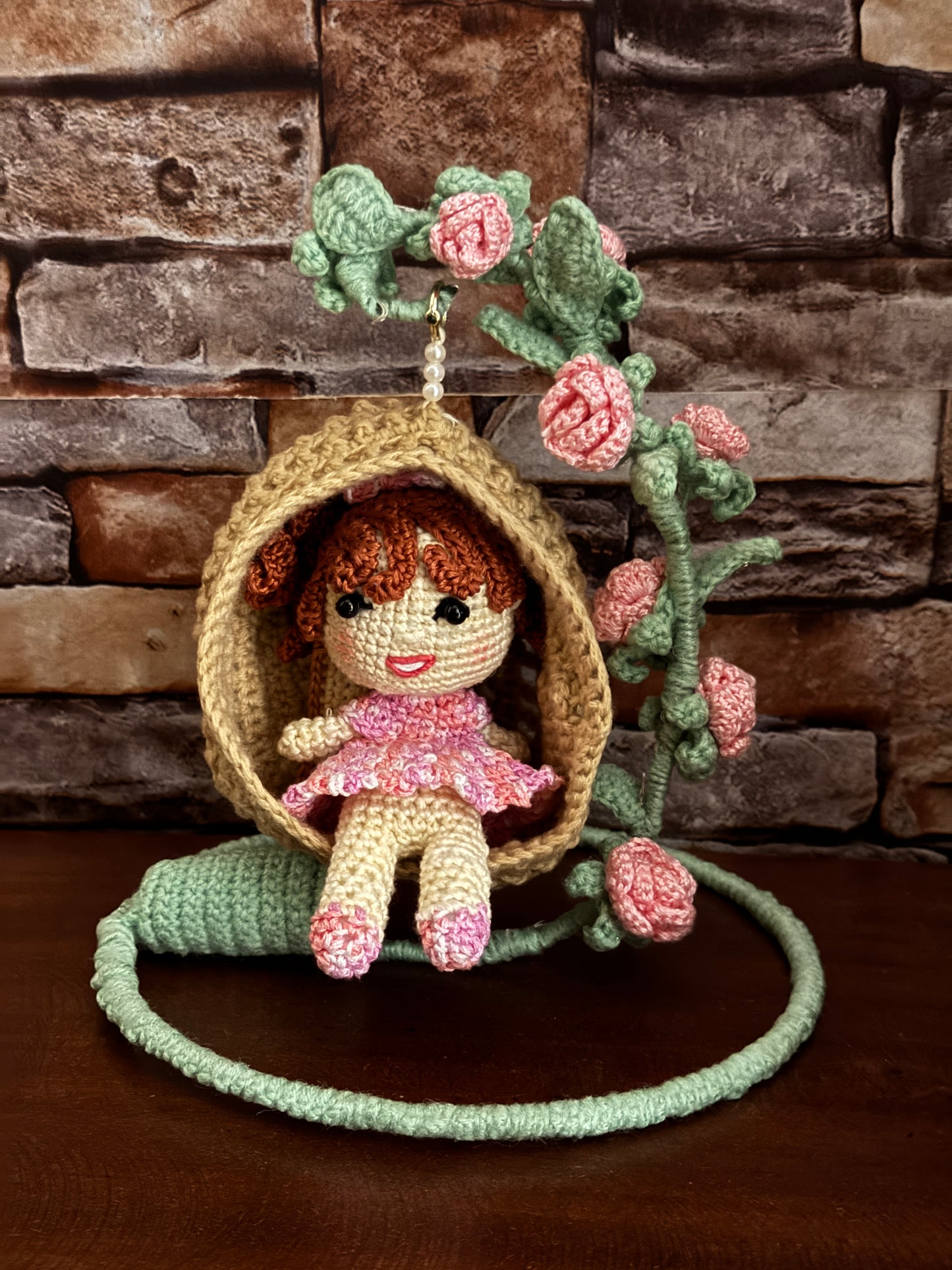 Girl in a swing adorned with flowers - handcrafted crochet decor with LED lights