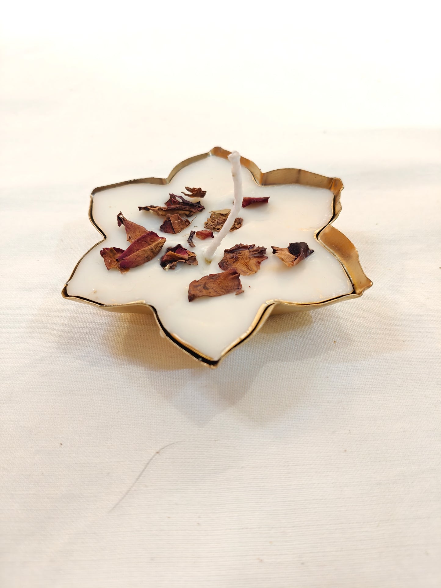 Flower shaped decorative metal base with dry flowers decorated wax candle