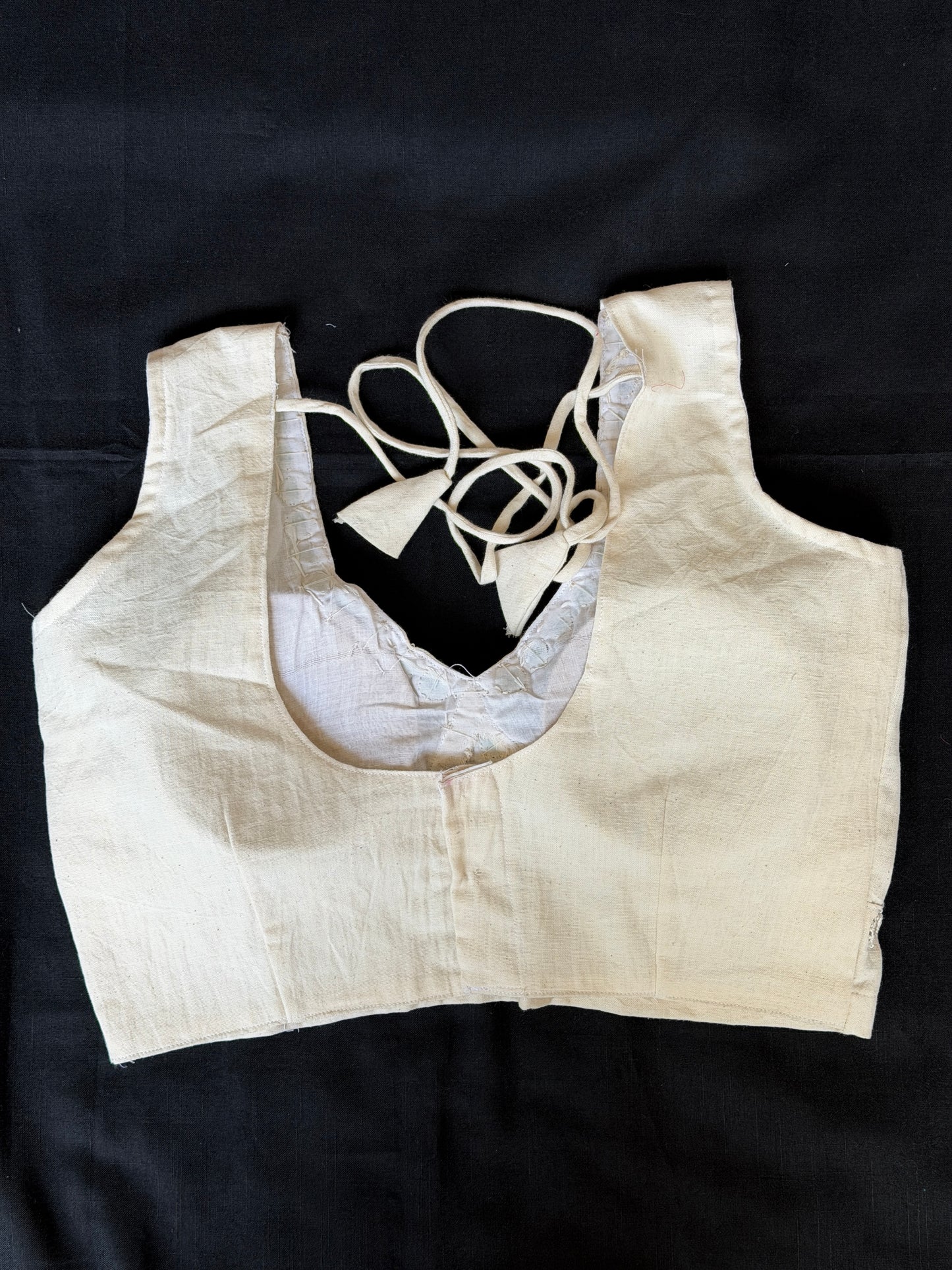 Off white handloom kala cotton sleeveless blouse with mirror work along the bust line