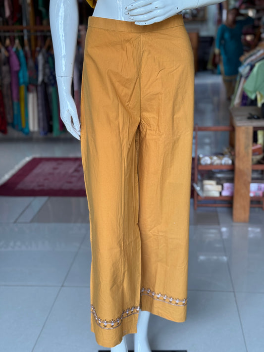 Mustard cotton pants with embroidery detailing at hem line