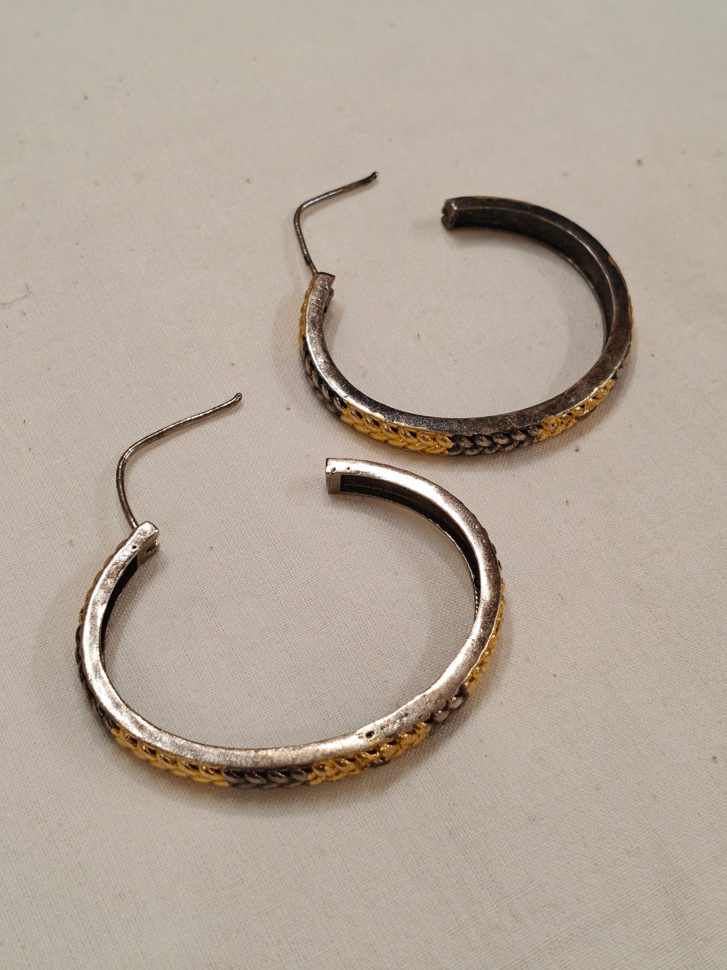 Gold and silver hoop earrings with braided design