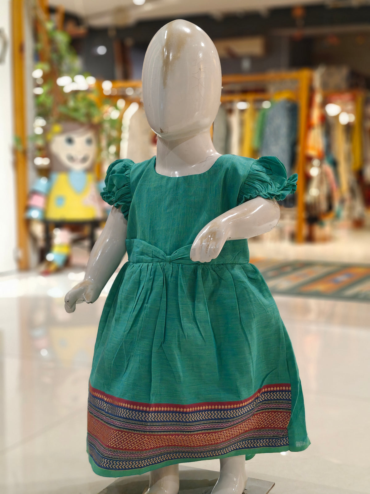 Green cotton ethnic frock with puffed sleeves for girls with colorful border