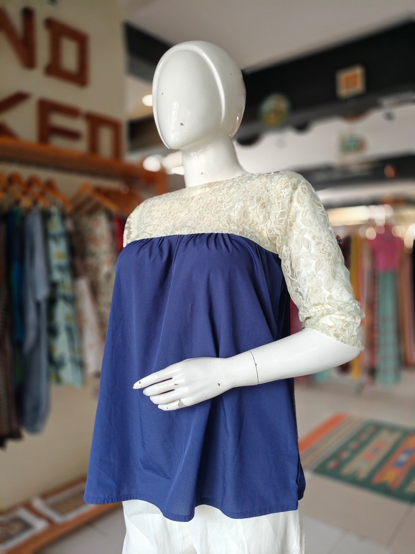 Navy blue top featuring cream lace sleeves and yoke