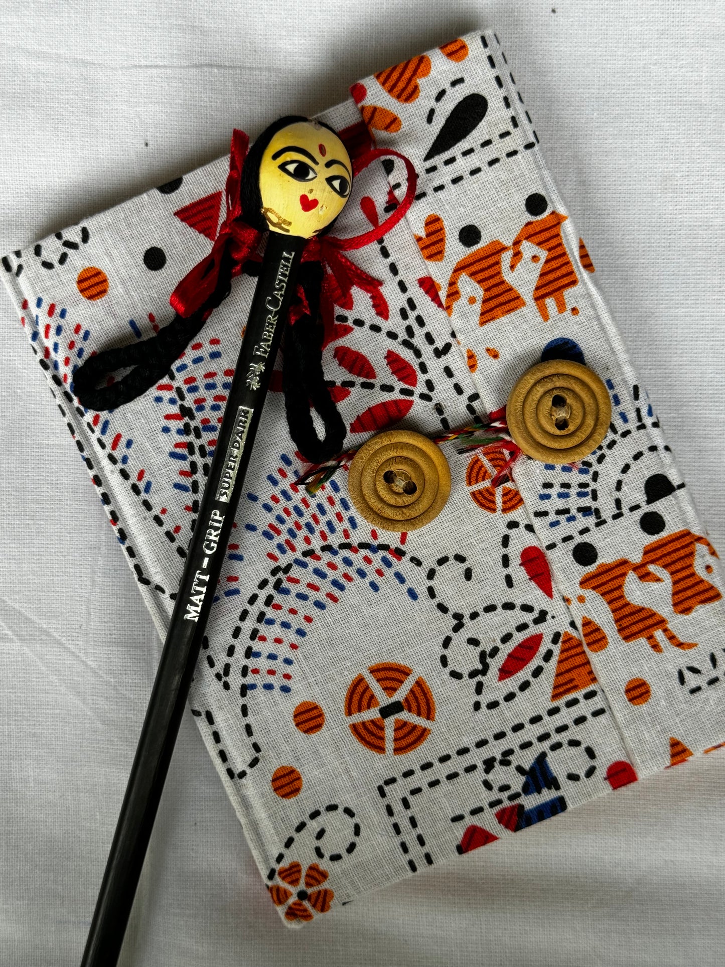 Pocket notebook with fabric cover with button and thread closure