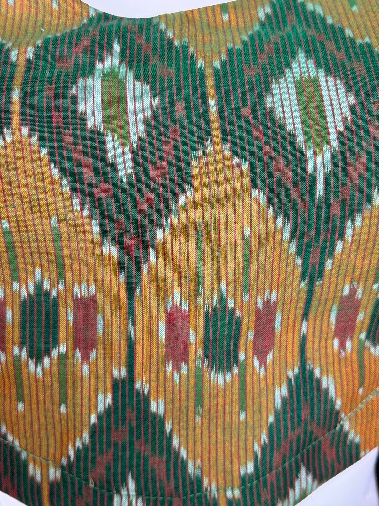 Dark green ikat cotton sleeveless blouse with curved waist line