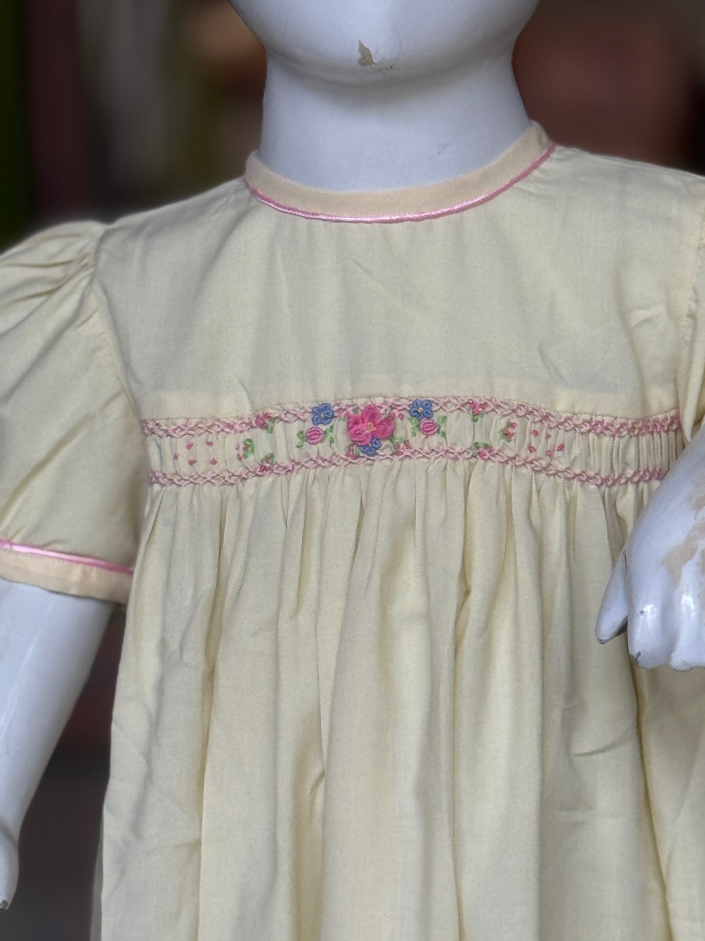 Light yellow hand embroidered smocking cotton frock for girls with piping at neck line