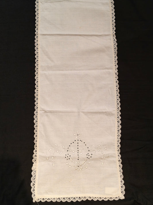 White embroidered and cutworked table runner with scalloped lace borders