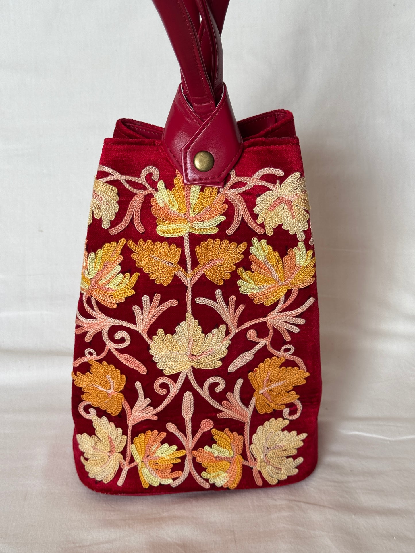 Potli bags with Kashmiri floral Aari embroidery - interesting twist around handle button closure