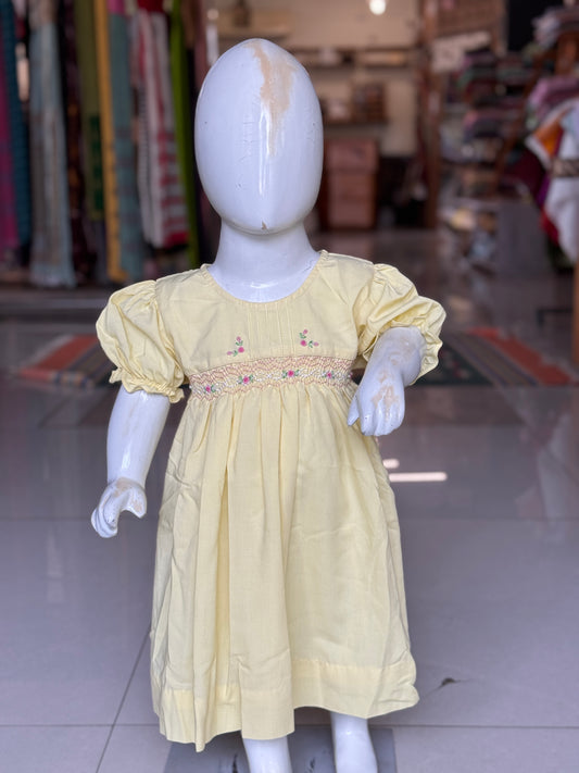 Light yellow hand embroidered smocking cotton frock for girls with vertical pintucks at neck