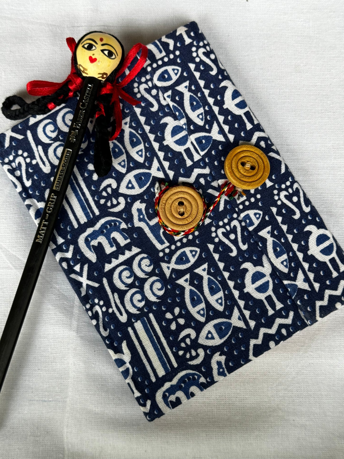 Pocket notebook with fabric cover with button and thread closure