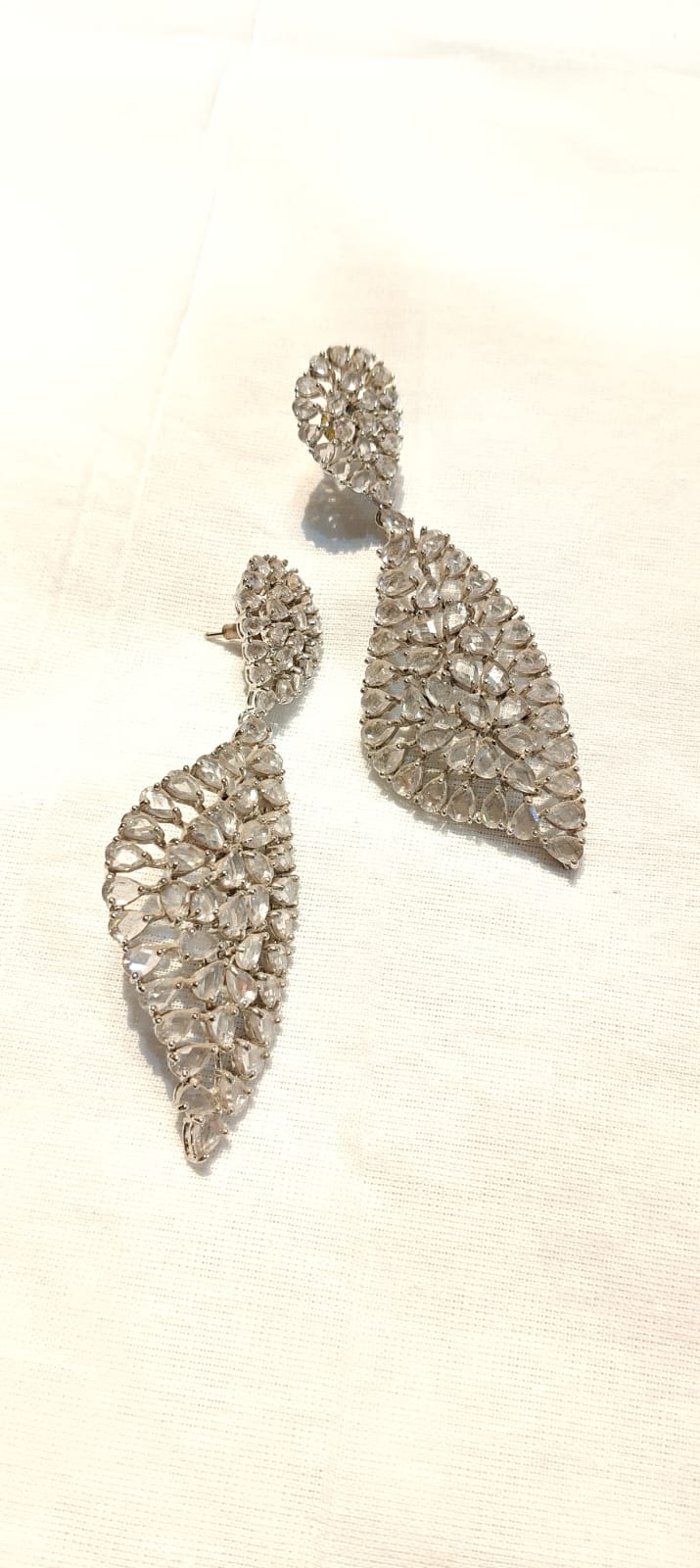 Crystal stone studded long earrings in silver tone