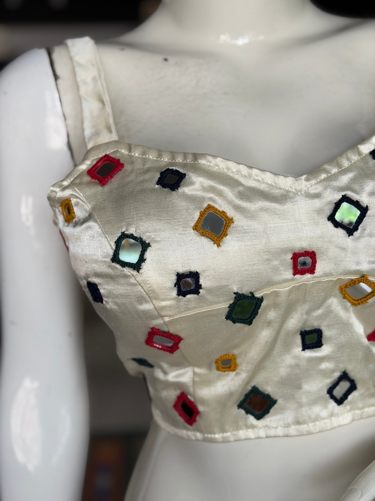 Off white mashru sleeveless blouse with all over colorful mirror work on front and back