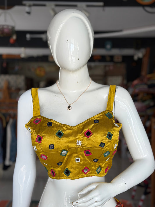 Mustard yellow mashru sleeveless blouse with all over colorful mirror work on front and back