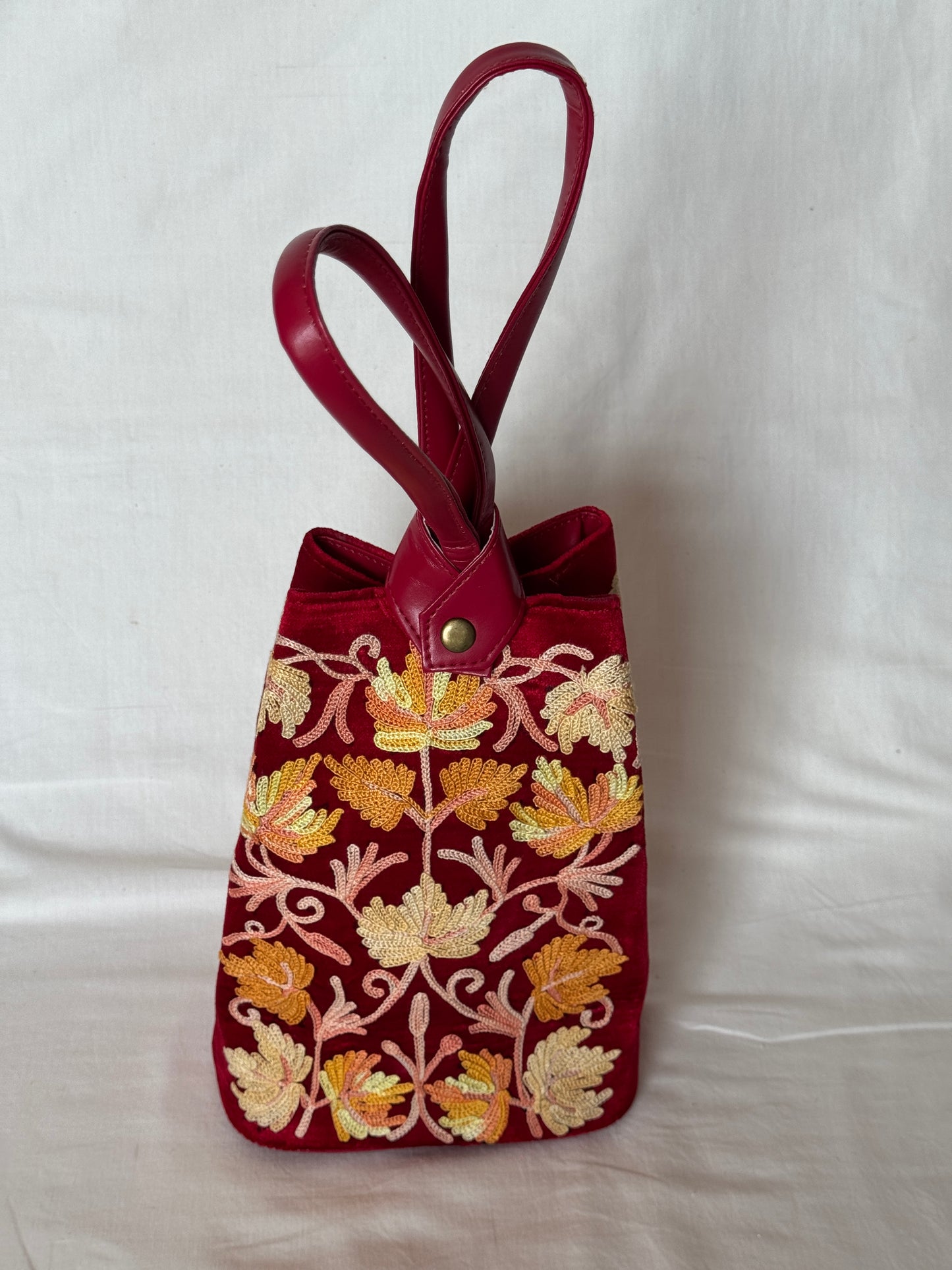 Potli bags with Kashmiri floral Aari embroidery - interesting twist around handle button closure