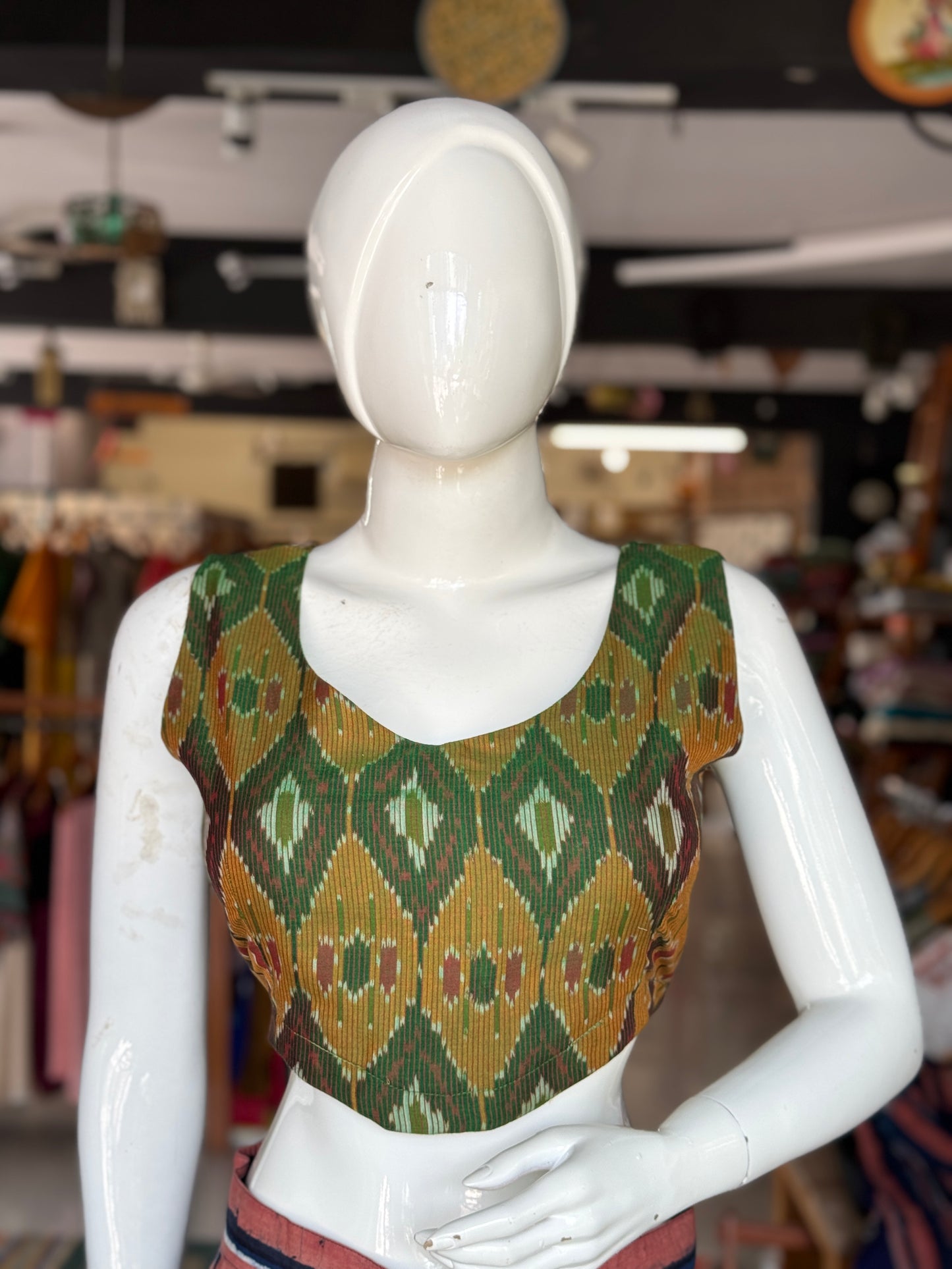 Dark green ikat cotton sleeveless blouse with curved waist line