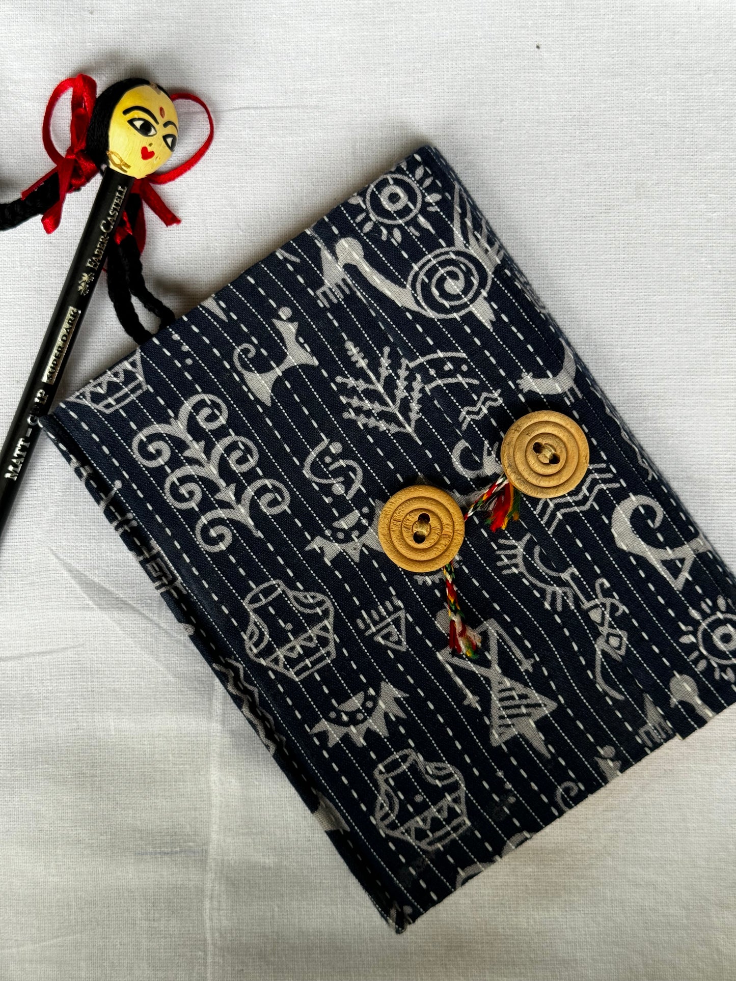 Pocket notebook with fabric cover with button and thread closure