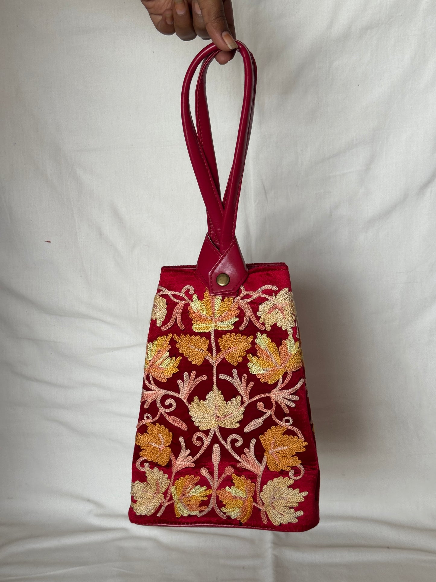 Potli bags with Kashmiri floral Aari embroidery - interesting twist around handle button closure