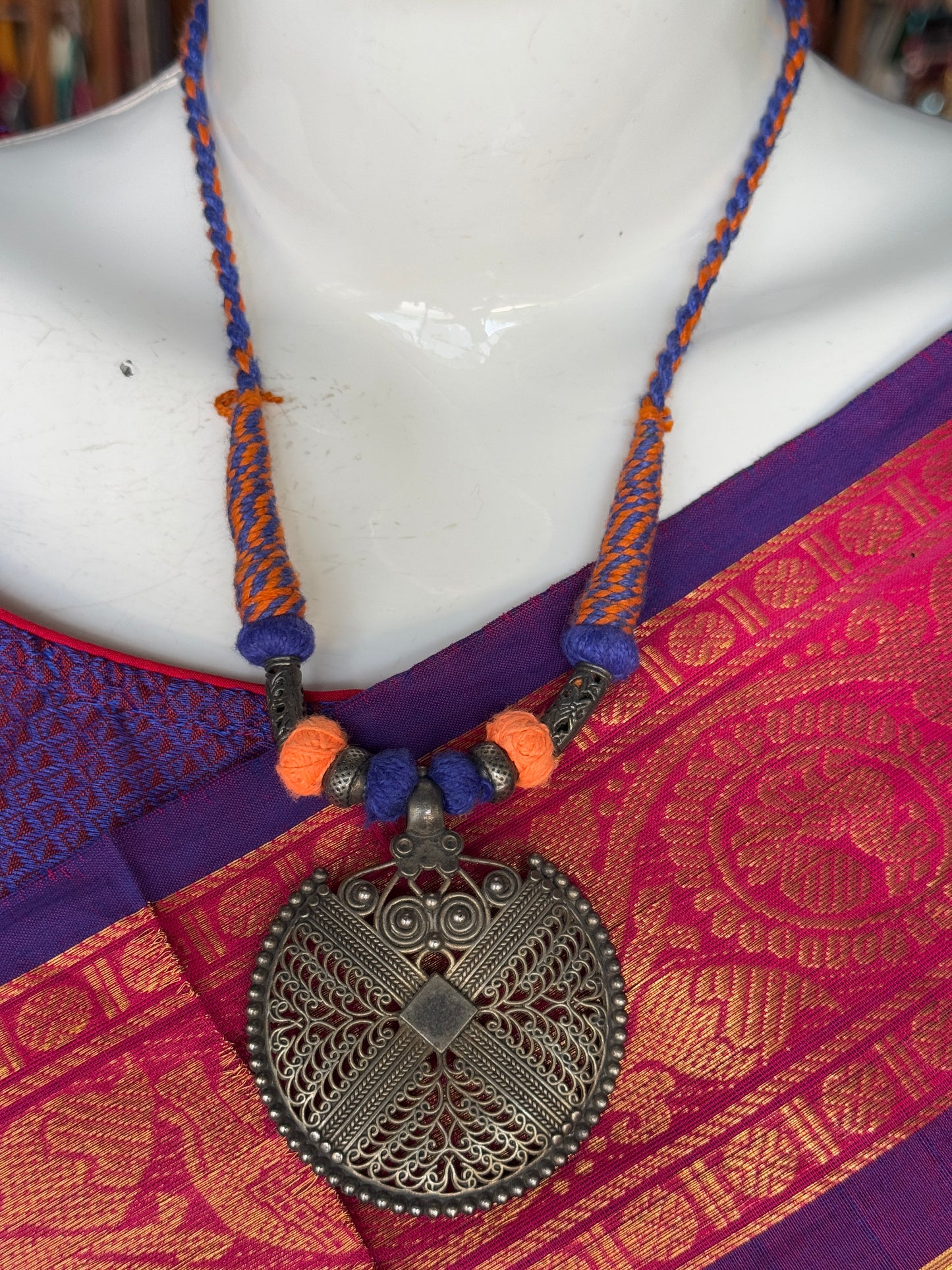 Orange and blue thread with circular pendant oxidised neckpiece