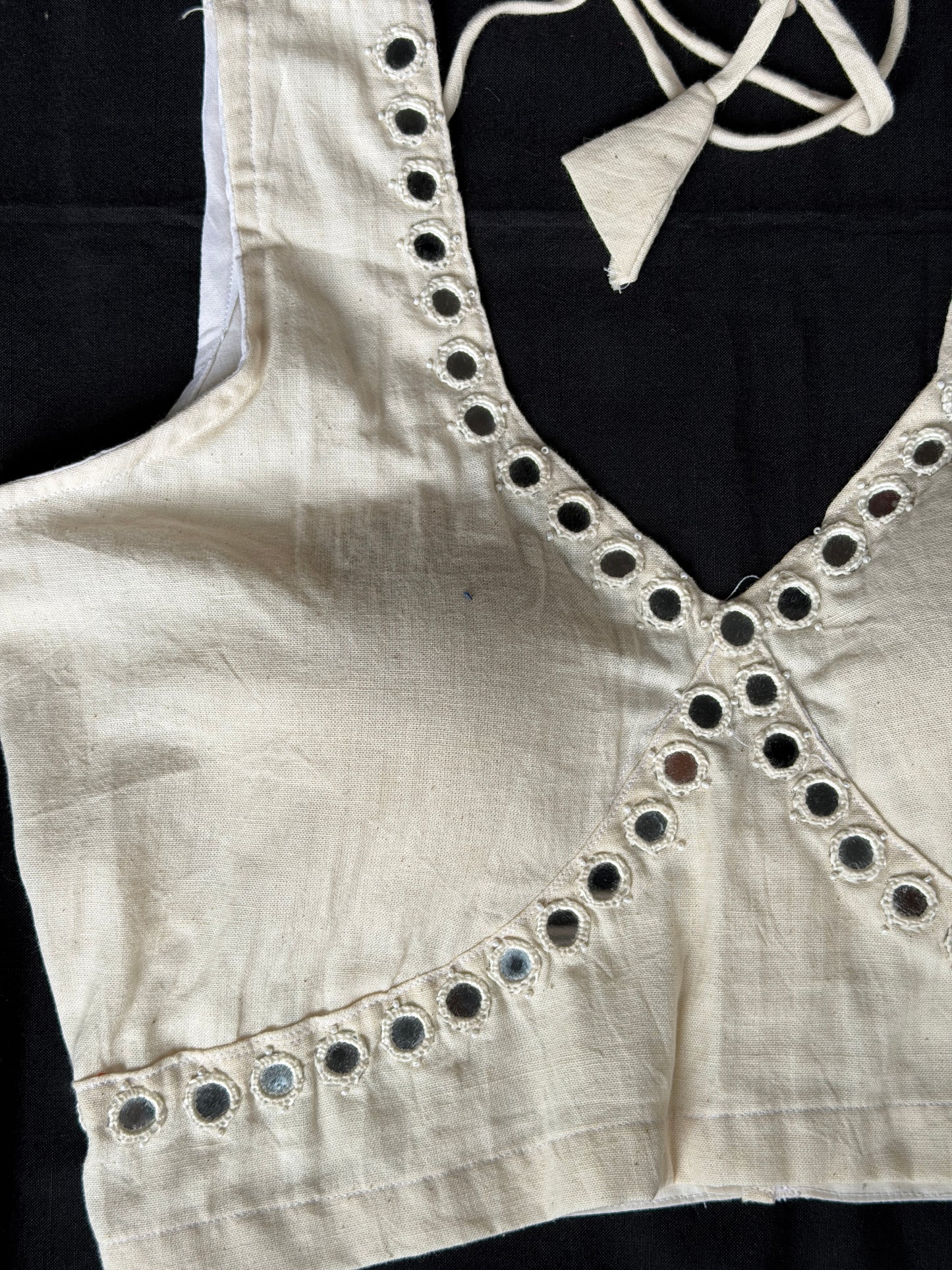 Off white handloom kala cotton sleeveless blouse with mirror work along the bust line