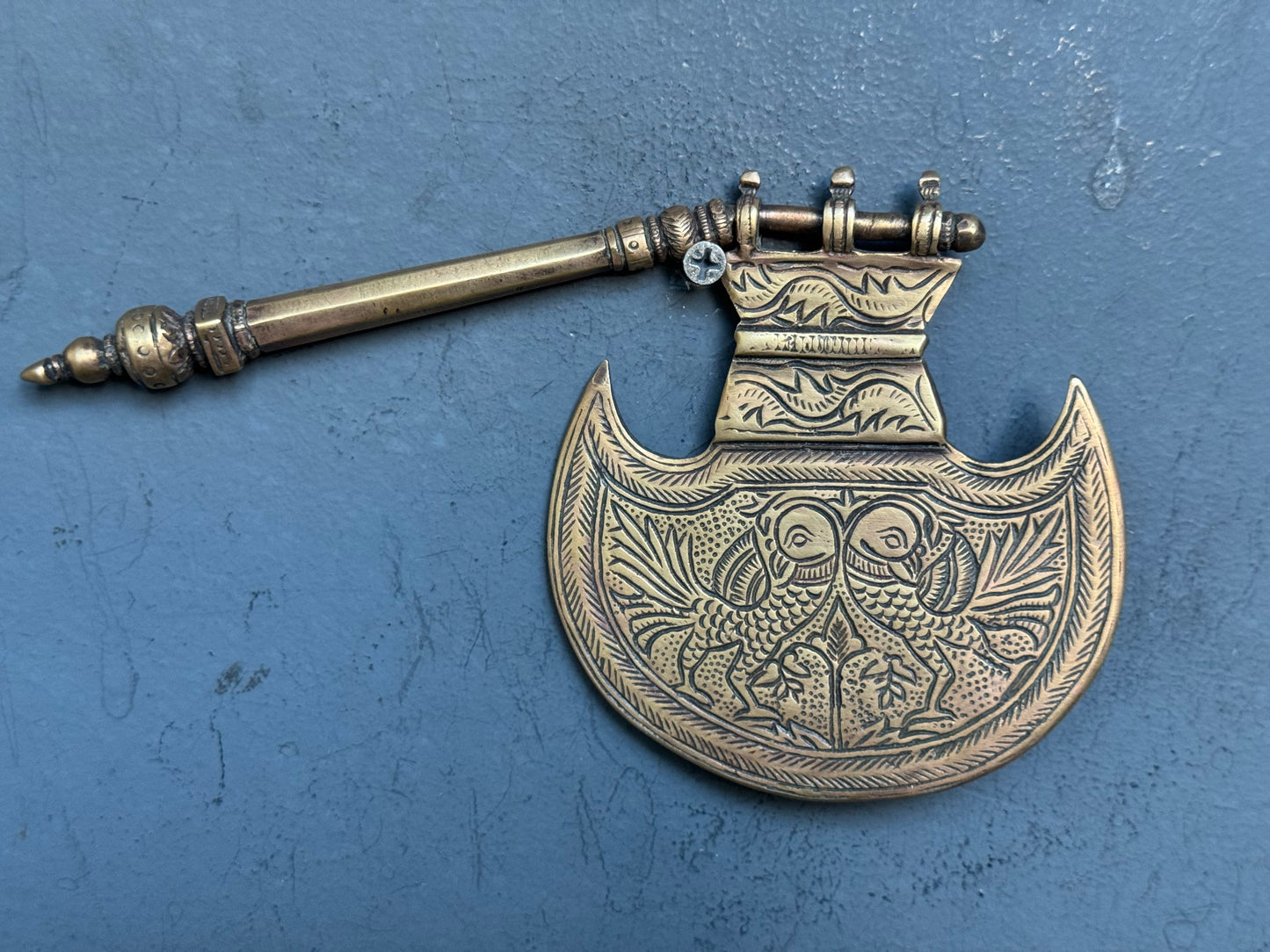 Vintage brass decorative fan with different engraved designs on both sides