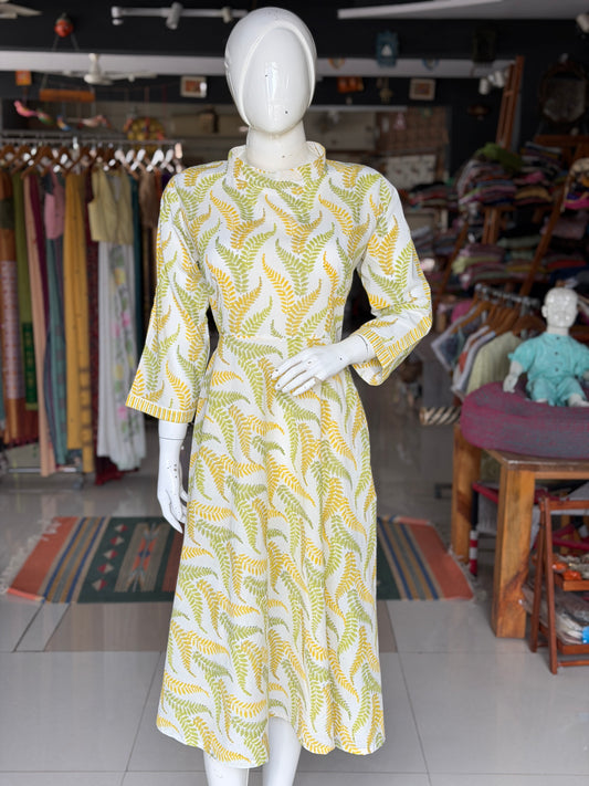 Yellow and green leaves on white,  hand block printed cotton umbrella dress with band collared neck and long sleeves