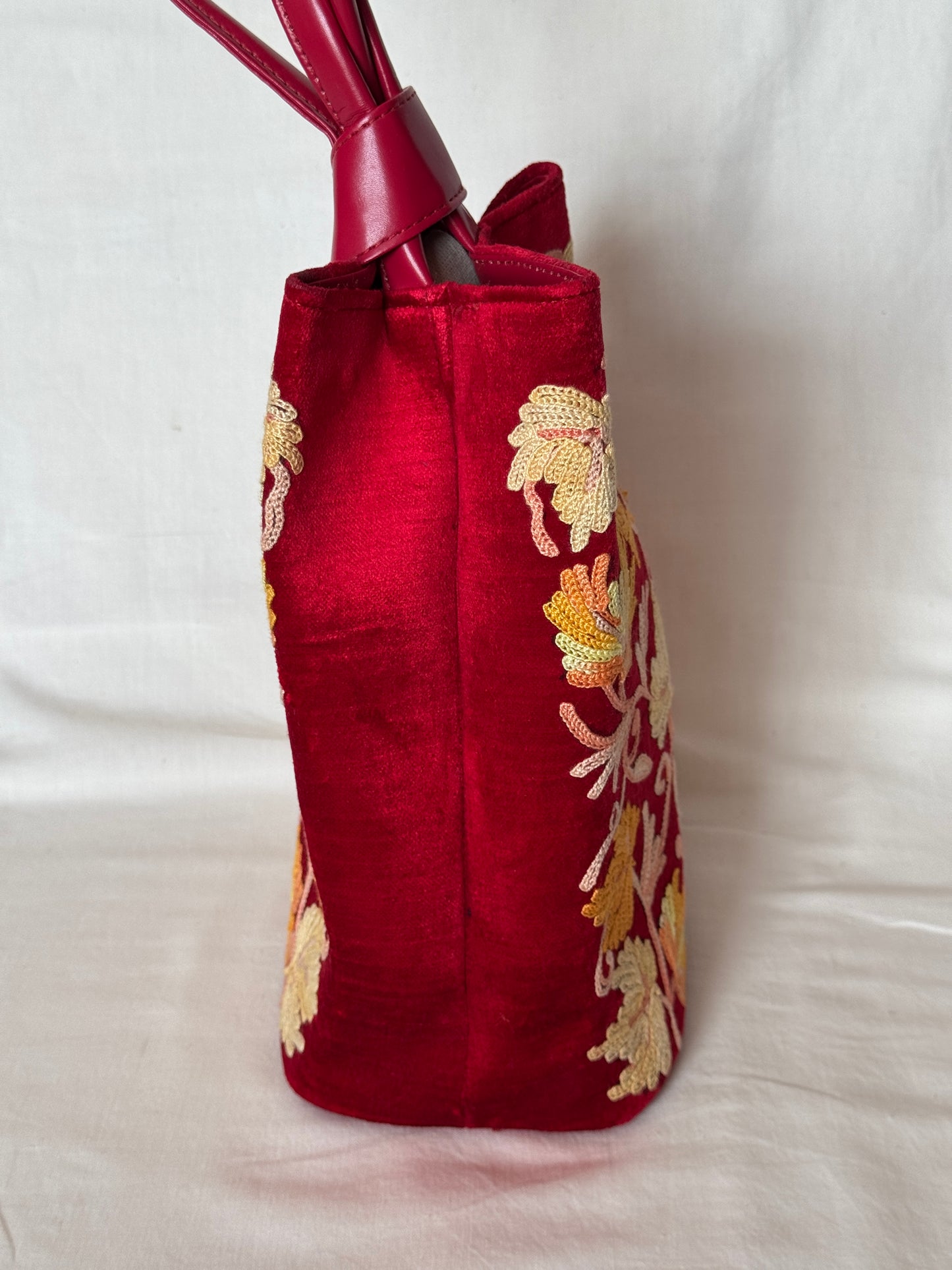 Potli bags with Kashmiri floral Aari embroidery - interesting twist around handle button closure