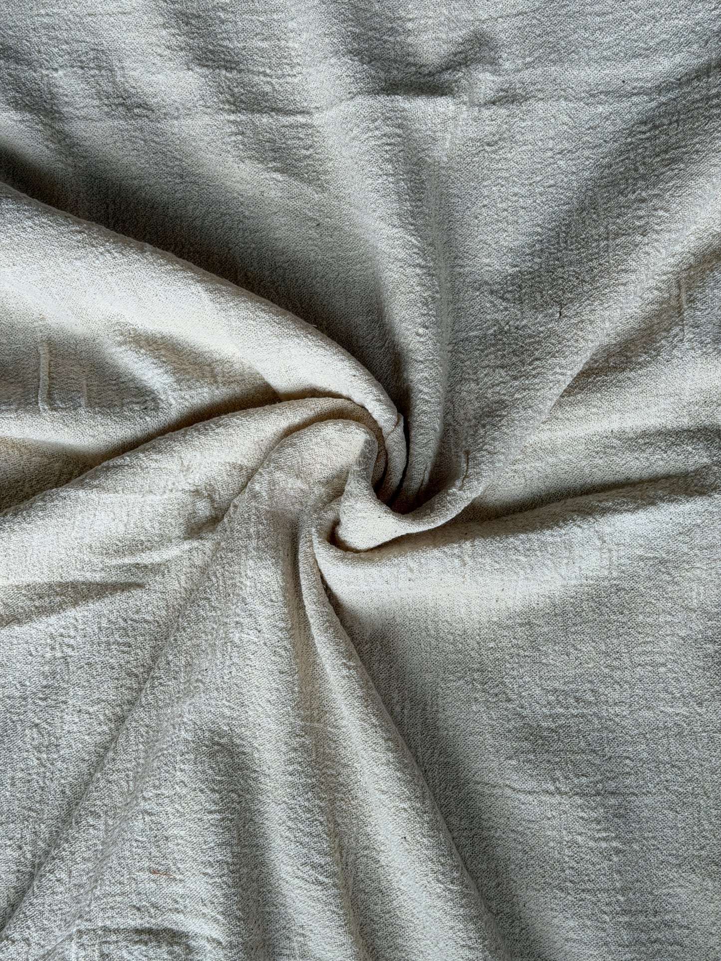 Off white cotton hand spun, hand woven fabric with textured stretch style weave