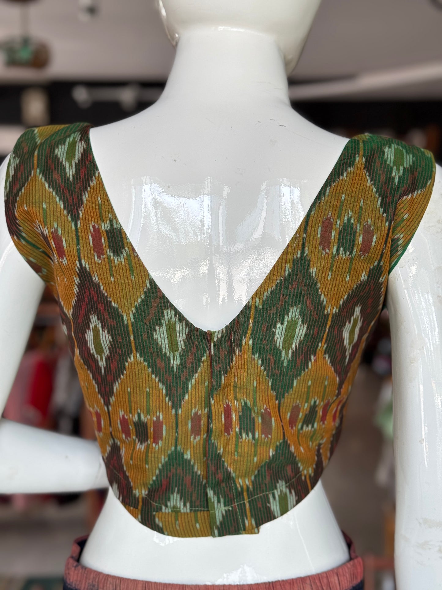 Dark green ikat cotton sleeveless blouse with curved waist line