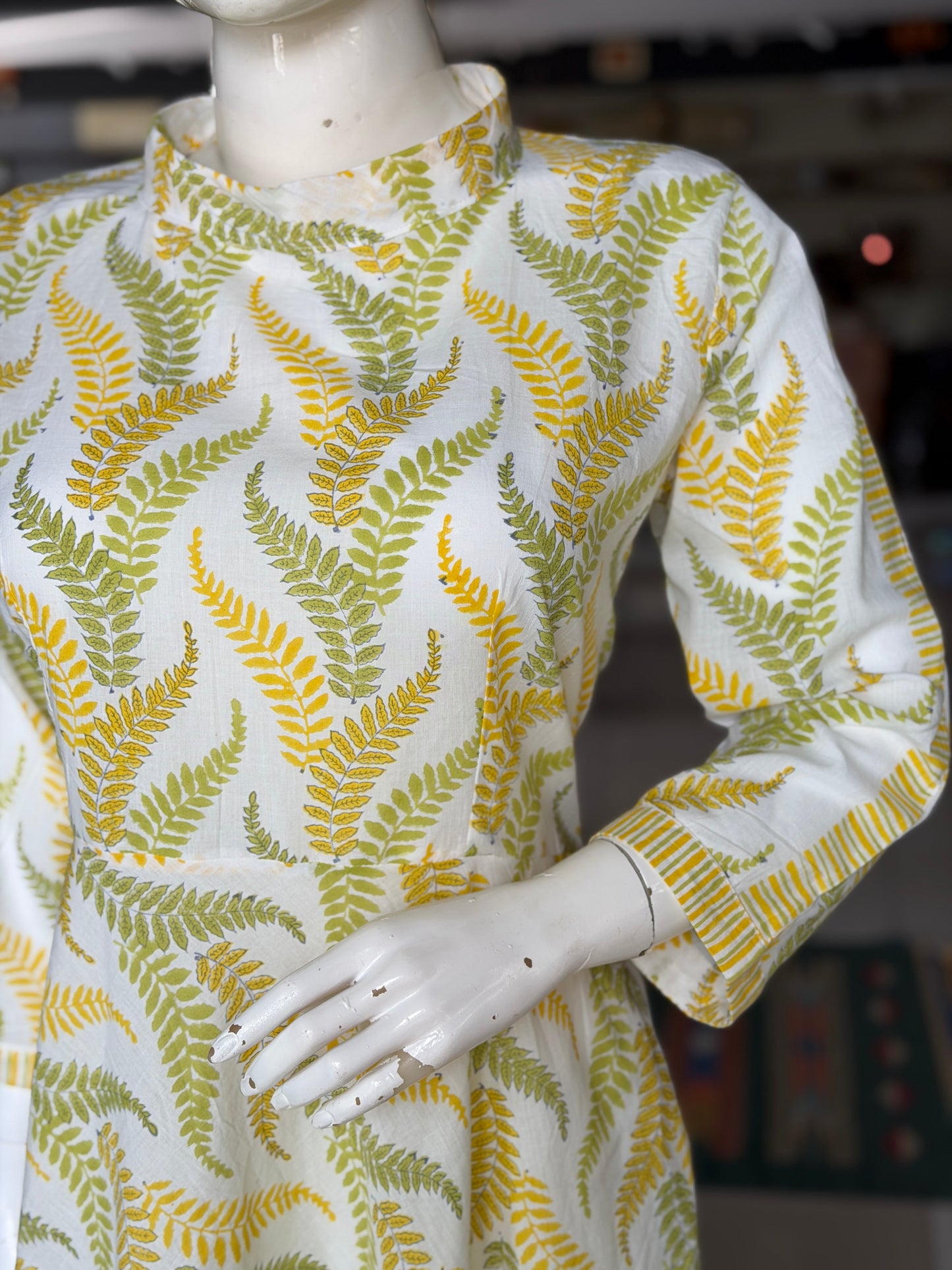 Yellow and green leaves on white,  hand block printed cotton umbrella dress with band collared neck and long sleeves