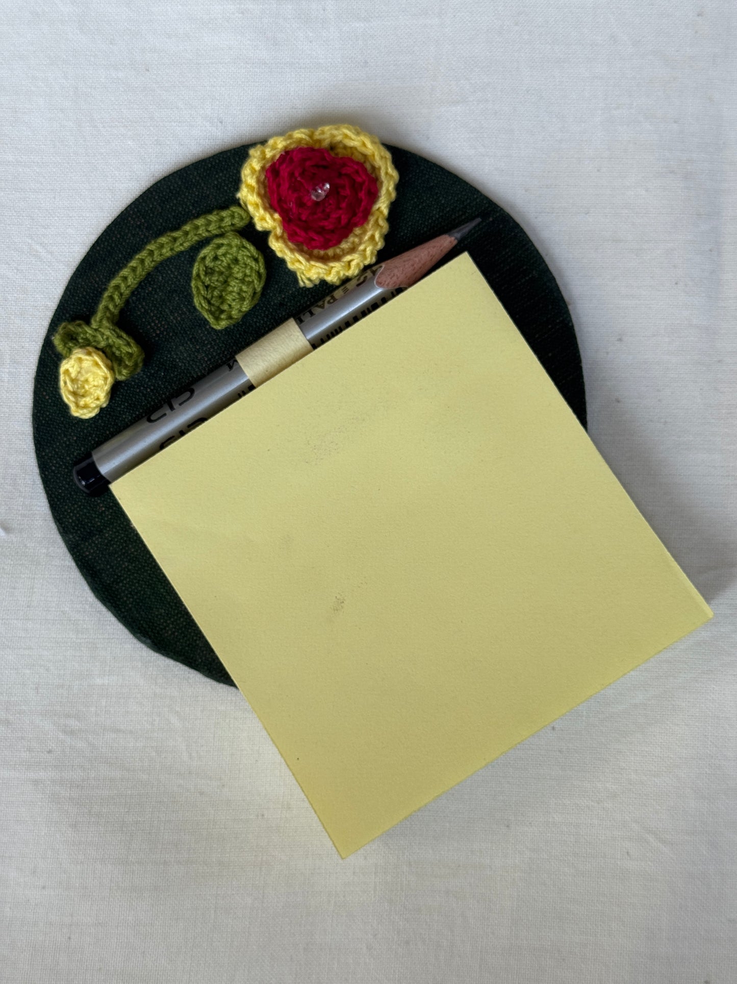 Round fridge magnet with crochet detailing to keep your shopping / to-do list handy