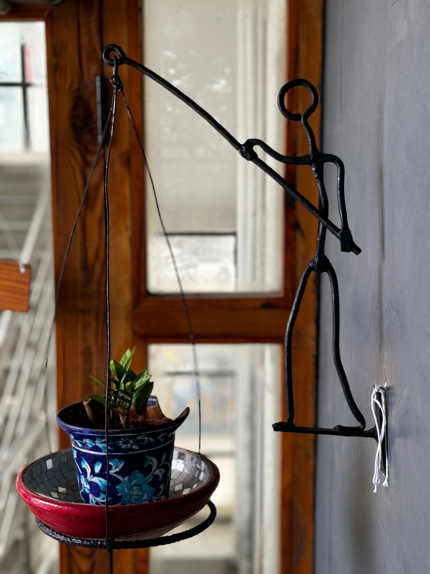 Man carrying a pot holder - wrought iron handcrafted wall decor