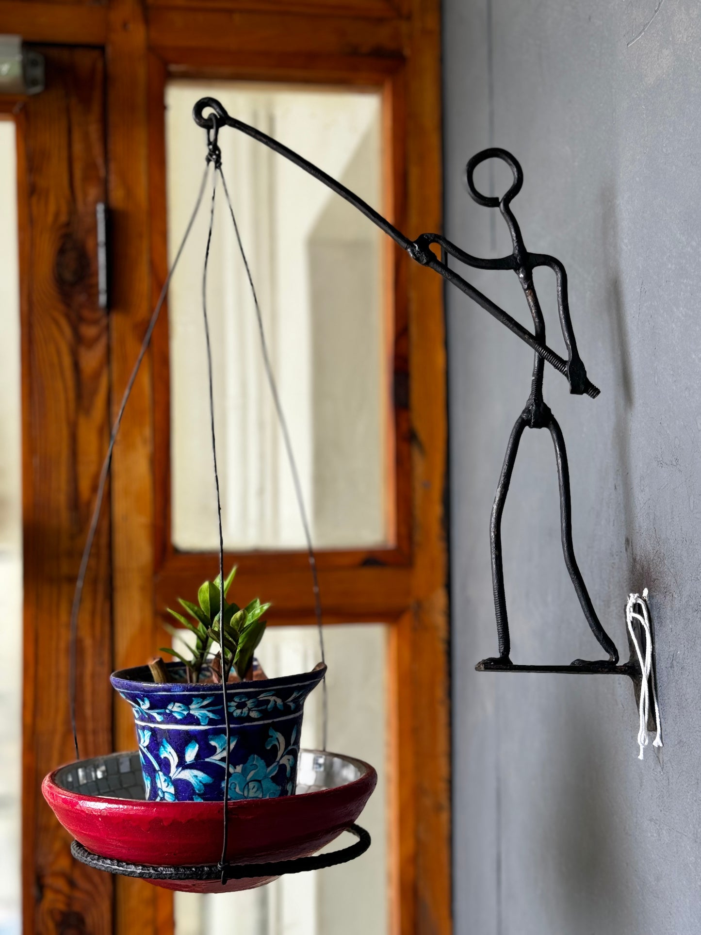 Man carrying a pot holder - wrought iron handcrafted wall decor