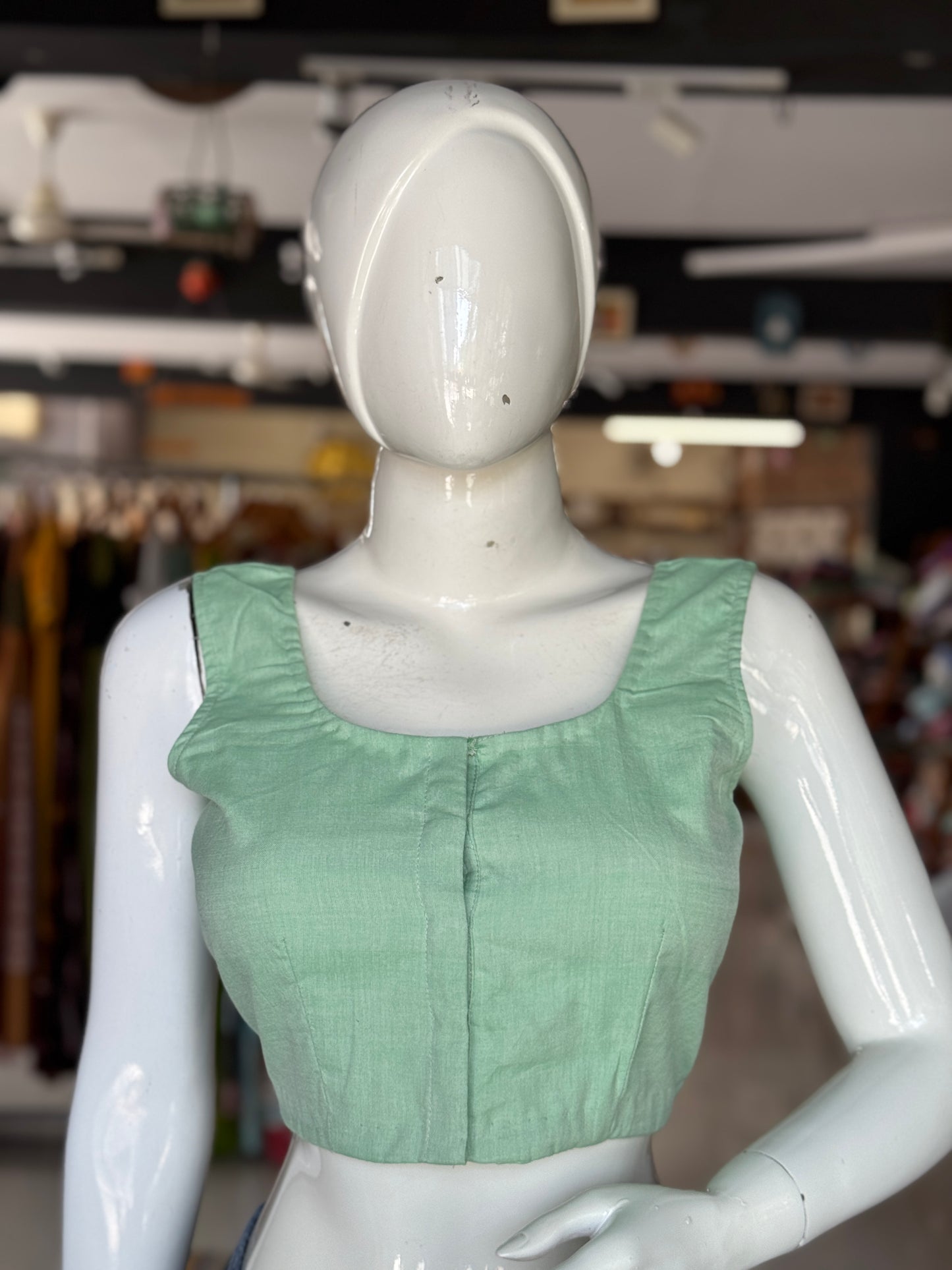 Green cotton sleeveless handloom blouse with hand embroidered flower on the back
