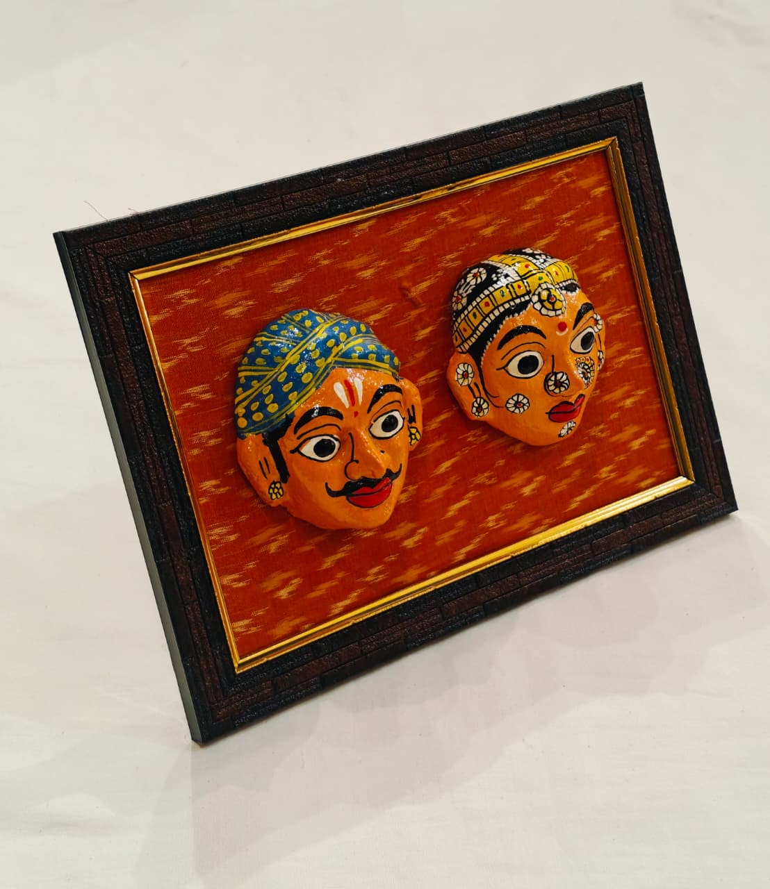 Cheriyal man and woman handcrafted masks pair on ikat background wall frame