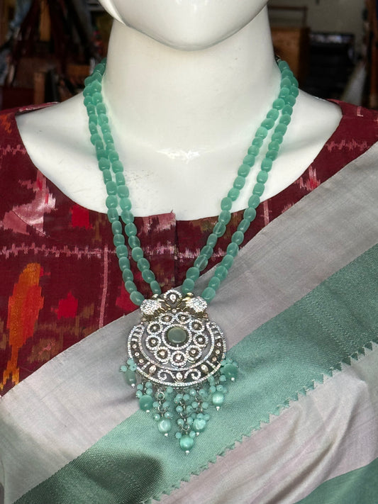 Sea green stone studded double line neckpiece and earrings set with elephants design