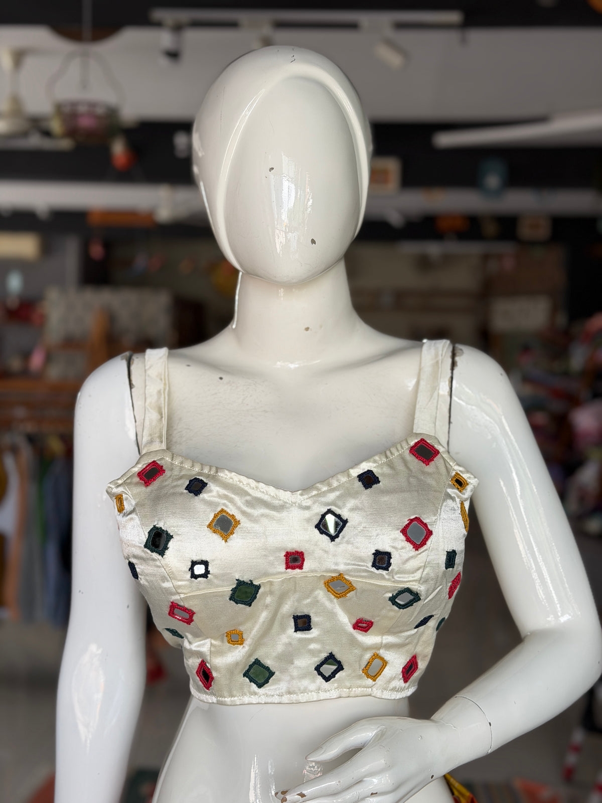 Off white mashru sleeveless blouse with all over colorful mirror work on front and back