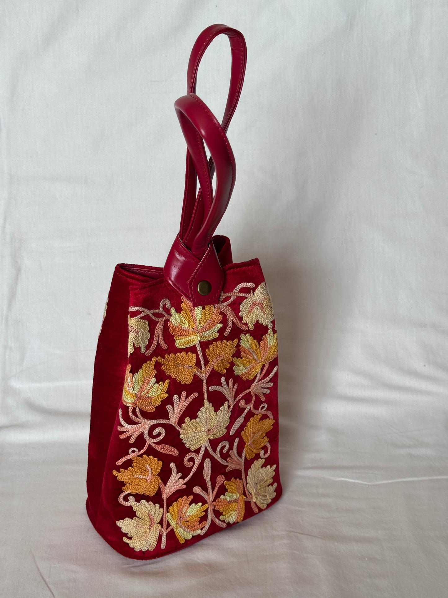 Potli bags with Kashmiri floral Aari embroidery - interesting twist around handle button closure