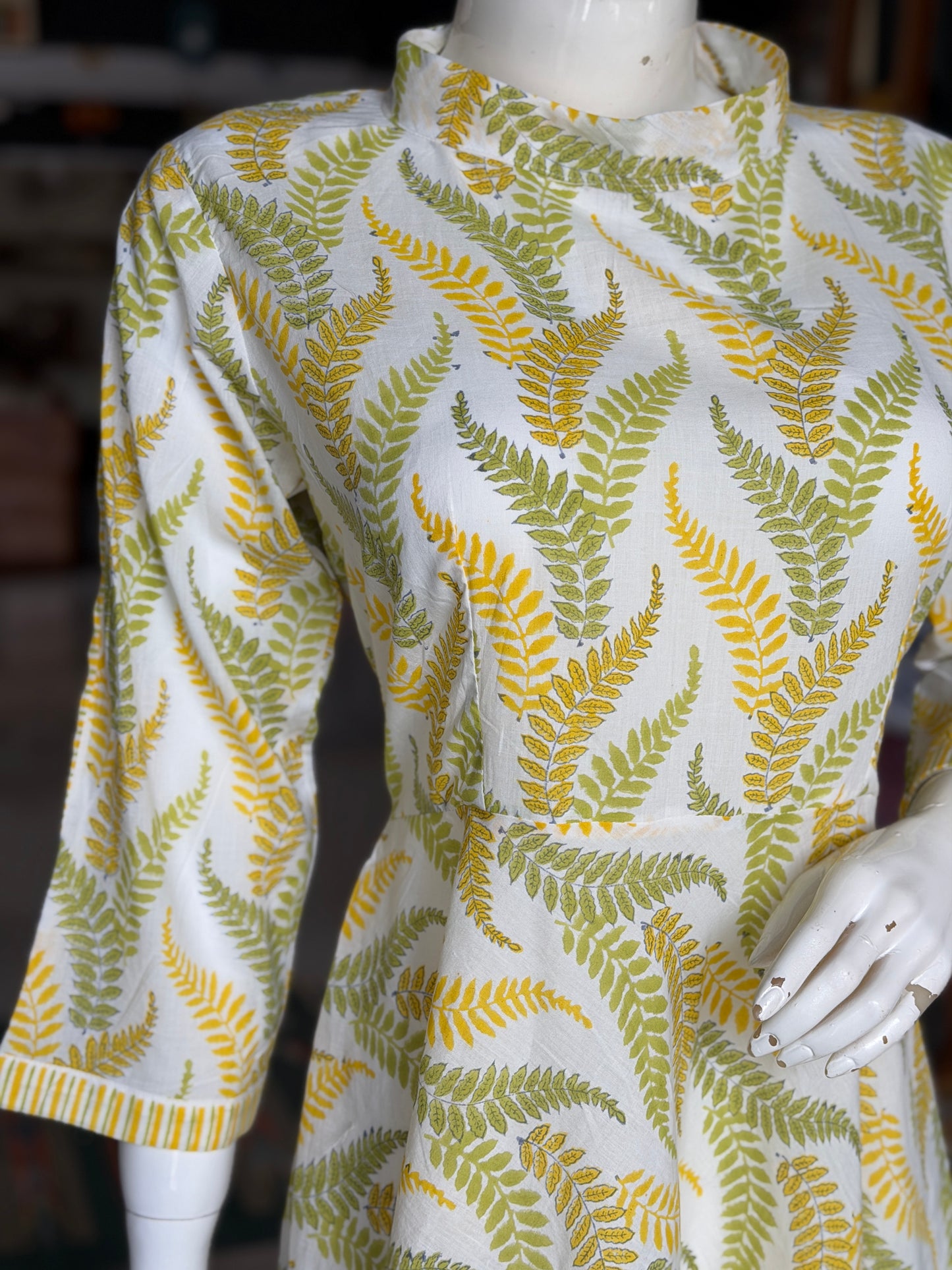 Yellow and green leaves on white,  hand block printed cotton umbrella dress with band collared neck and long sleeves
