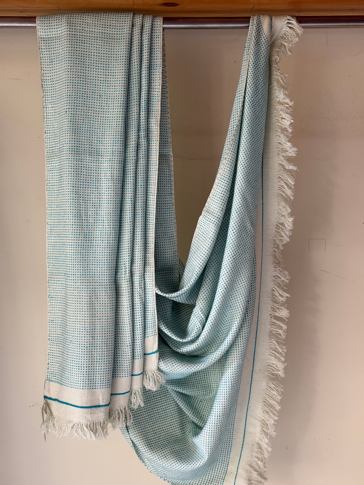 Off-white handwoven cotton sofa throw with blue woven stripes all over