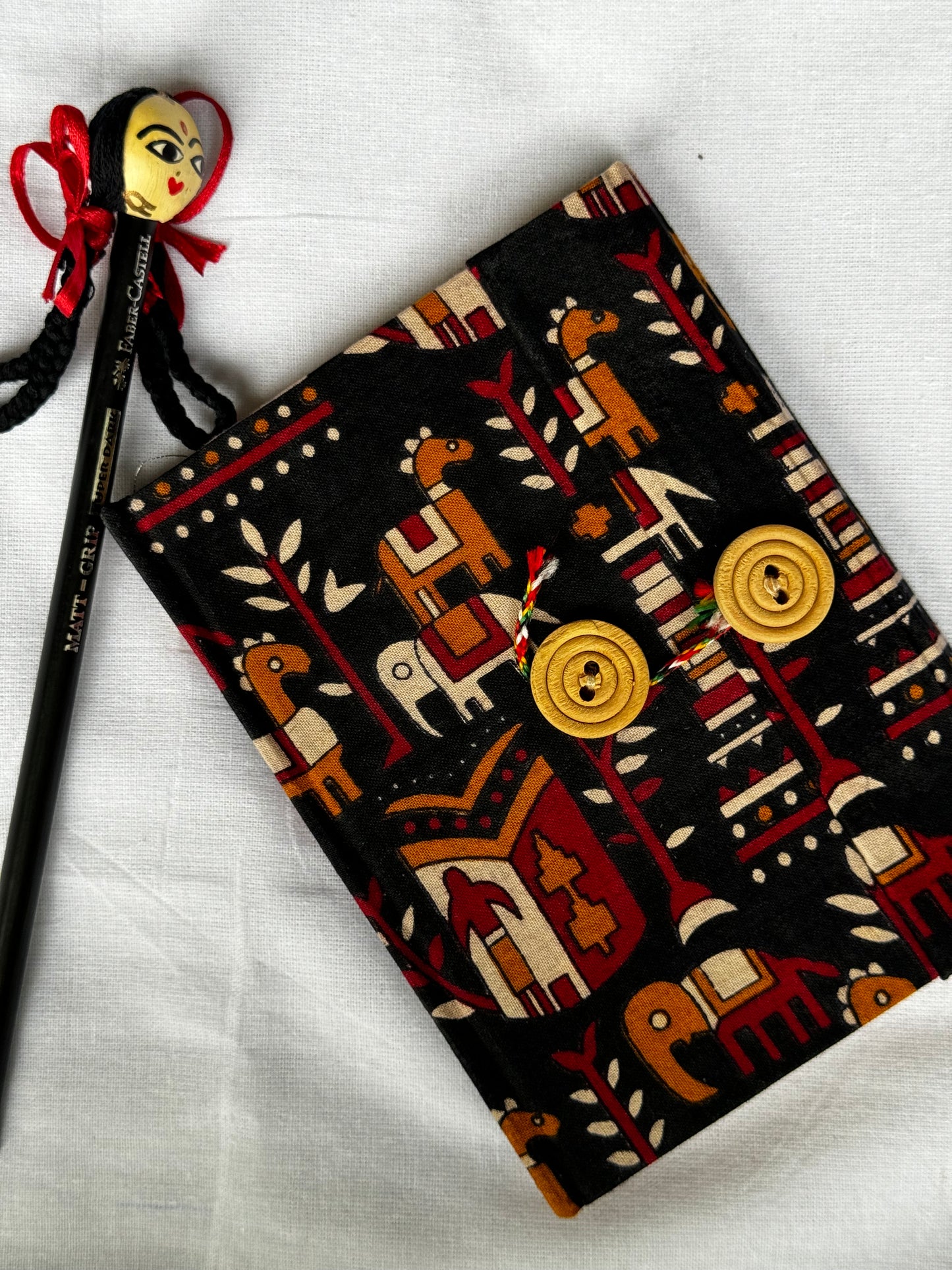 Pocket notebook with fabric cover with button and thread closure