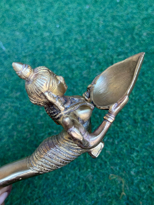 Lady holding Diya with long mermaid handle - handcrafted in brass